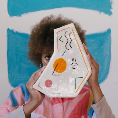 creative female artist with painted vase in modern studio
